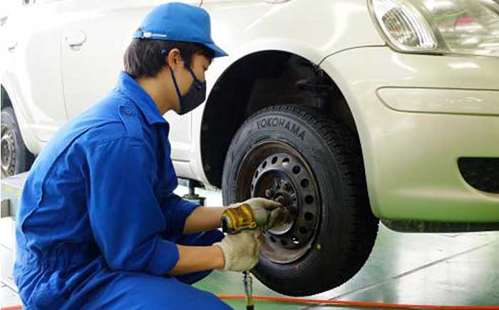 横浜ゴムの乗用車用タイヤを寄贈車両に装着する石巻専修大学の学生。